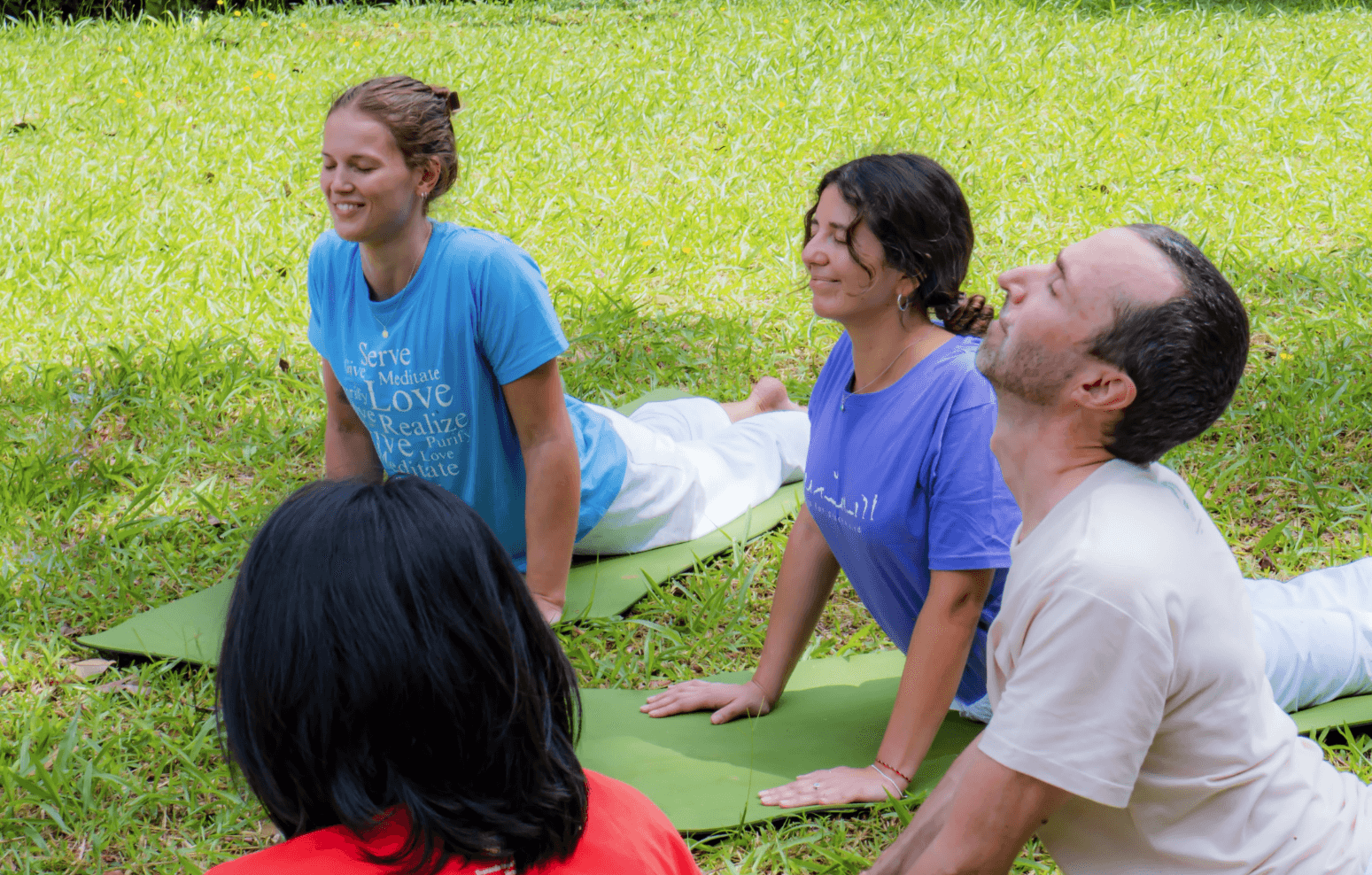 Students practicing Bhujangasana (Cobra pose) outdoors